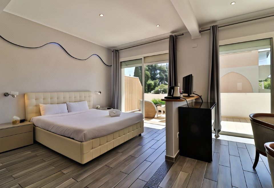 a spacious bedroom with a king - sized bed , hardwood floors , and a sliding glass door leading to a patio at Hôtel Restaurant de la Mer