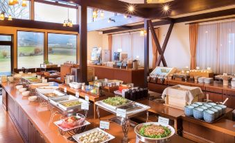 a large buffet table filled with a variety of food items , including fruits , vegetables , and meats at Hotel Hakuba