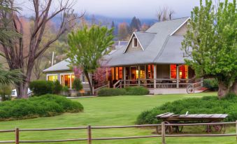 a large house with a porch and two other smaller houses in front of it at Sierra Sky Ranch, Ascend Hotel Collection