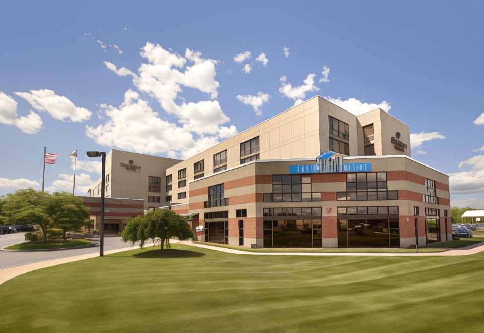 "a large building with a sign that reads "" the citadel "" is surrounded by a grassy area and trees" at DoubleTree by Hilton Hartford - Bradley Airport