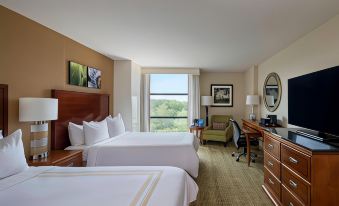 a hotel room with two beds , a desk , and a window , all decorated in white and brown colors at Atlanta Marriott Alpharetta
