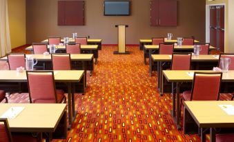 a large conference room with rows of chairs arranged in a semicircle , and a podium at the front of the room at Courtyard Burlington Mt. Holly/Westampton