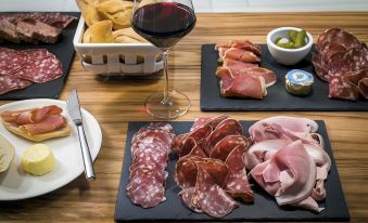 a dining table with a variety of meats , bread , and wine on it , ready for a meal at Okko Hotels Toulon Centre