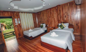 a hotel room with two beds , one on the left and one on the right side of the room at Palmsuay Resort