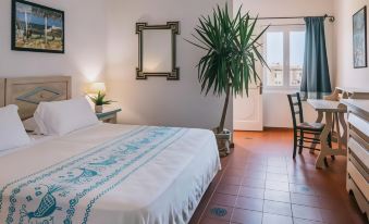 a small , white bedroom with a bed , a chair , and a window , decorated with plants and decorations at MClub Marmorata
