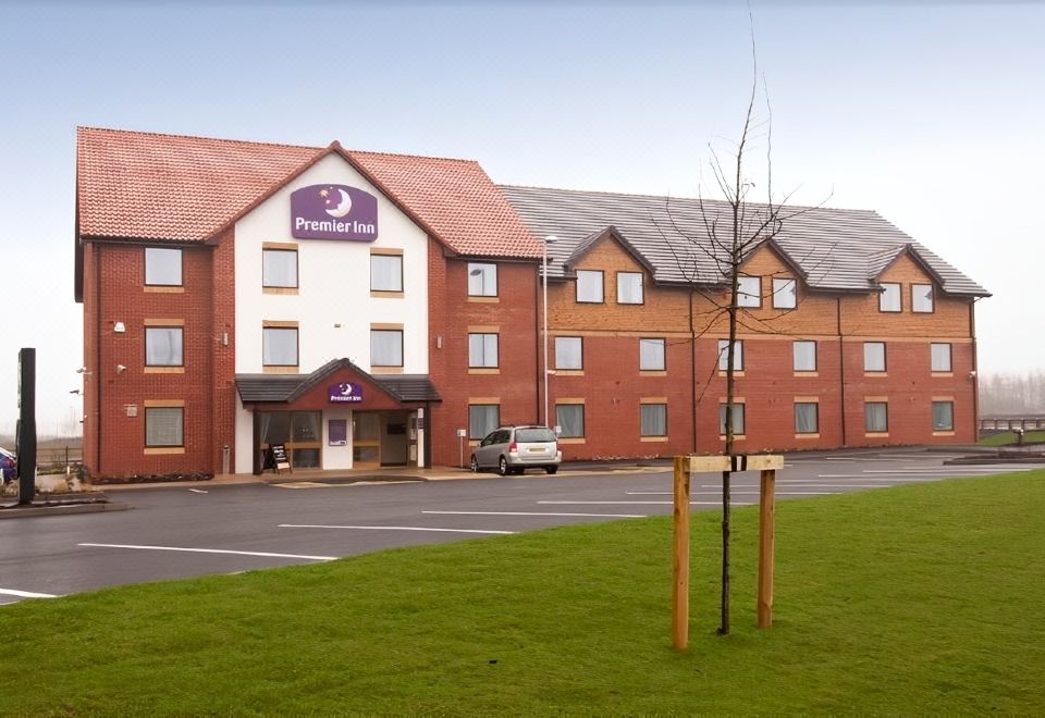 "a hotel with a red brick exterior and a sign that reads "" premier inn "" on the front" at Rugeley