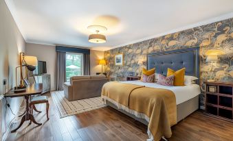 a modern hotel room with a large bed , wooden floors , and a balcony view , decorated with blue floral wallpaper at Banchory Lodge Hotel