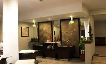 a modern hotel lobby with a reception desk , chairs , and potted plants , giving it a stylish and comfortable atmosphere at Horison Tirta Sanita Kuningan