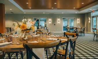 a well - decorated dining room with a table set for a meal , surrounded by various chairs and plates at Saranac Waterfront Lodge, Trademark Collection by Wyndham