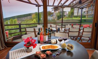 a table with a plate of food , wine glasses , and various other items is set up in an outdoor patio at Hotel Petradi