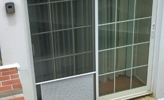 a sliding glass door with a glass window and metal bars is next to a brick wall at Seven Arches