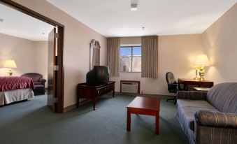 a spacious living room with a couch , coffee table , and other furniture in the background at Ramada by Wyndham Cumberland Downtown
