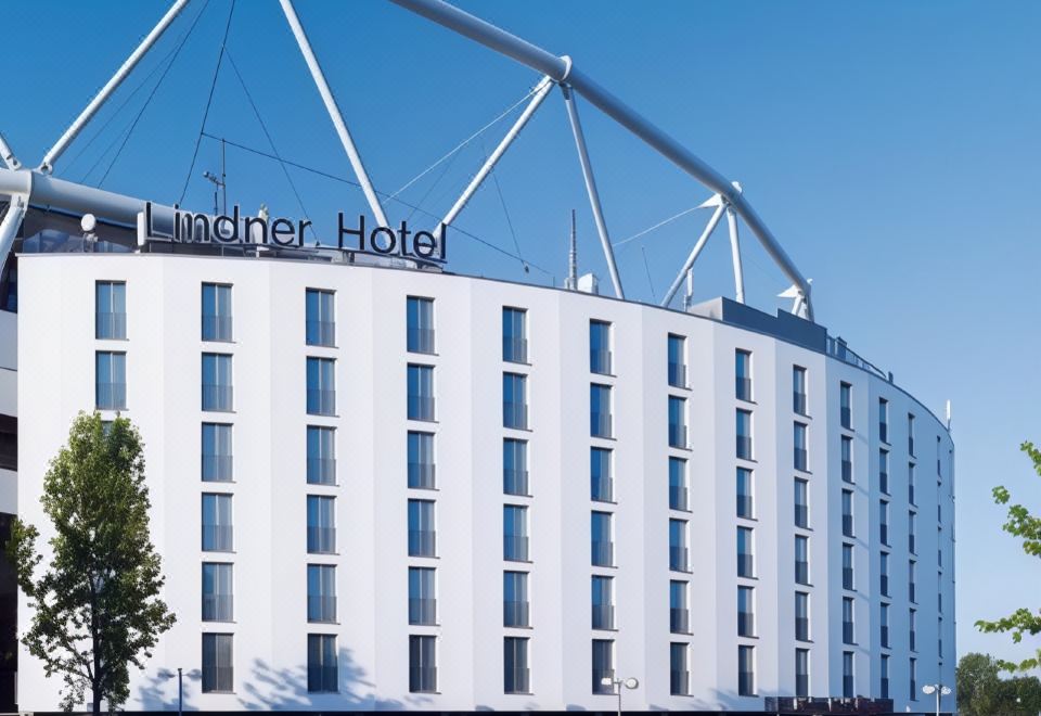 "a large white building with the words "" birdner hotel "" written on it , located in a city setting" at Lindner Hotel Leverkusen Bayarena