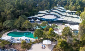 aerial view of a resort surrounded by trees and a lake , with multiple swimming pools visible at Kingfisher Bay Resort