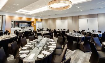 a large , empty conference room with multiple tables and chairs set up for a formal event at Quality Hotel Rules Club Wagga