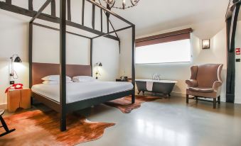 a bedroom with a large bed , a bathroom with a bathtub , and a cowhide rug on the floor at The Crown