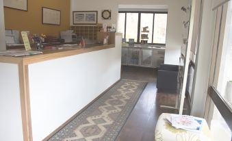 a small hotel lobby with a reception desk , a rug , and a window overlooking the ocean at Red Cedars Motel