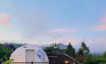 a white geodesic dome house is situated on a balcony with a view of the mountains at Khaopubpa Resort