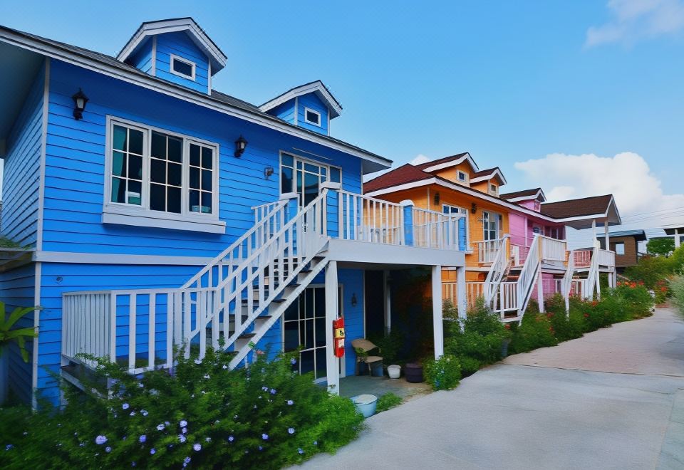 a row of colorful beach houses with a blue staircase leading up to the second floor at Bunny Hill Resort