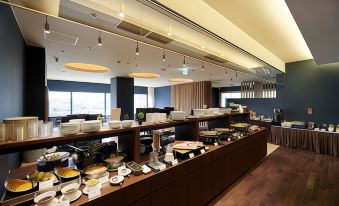 a large dining area with a buffet table filled with various food items , including bowls , cups , and utensils at Hotel Metropolitan Akita