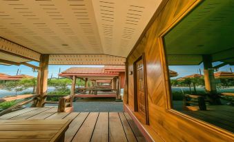 a wooden deck with two large windows , one on the left and one on the right at Palmsuay Resort