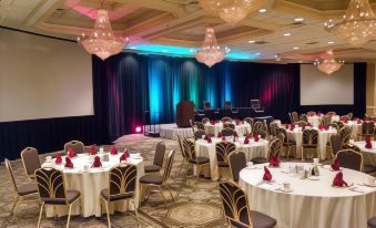 a large room with round tables and chairs set up for a formal event , possibly a wedding reception at Clayton Plaza Hotel & Extended Stay