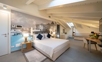 a large , modern bedroom with white walls , a comfortable bed , and a painting of a city skyline on the wall at Avenue Boutique Hotel