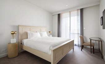 a large , white bed with a wooden headboard is situated in a bedroom next to a window at Knightsbridge Canberra