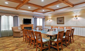 a large conference room with wooden chairs and a table , surrounded by a fireplace and a flat - screen tv at Country Inn & Suites by Radisson, Ft. Atkinson, WI