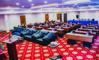 a large conference room with multiple chairs arranged in rows , and a red carpet covering the floor at Horison Express Sentani