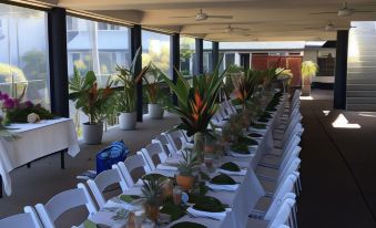 a long dining table set up for a formal event , with multiple chairs arranged around it at Rosslyn Bay Resort