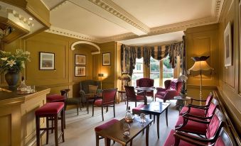 a large , well - lit room with multiple couches and chairs arranged in a cozy setting , creating a comfortable atmosphere for relaxation and socializing at Lovelady Shield Country House Hotel