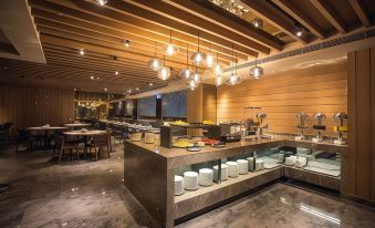 a modern , well - lit restaurant with wooden ceiling beams and large windows , featuring a bar counter and several dining tables at Airline Inn Kaohsiung Station