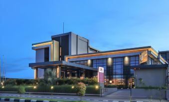 a modern building with large windows and a green roof , situated on a city street at Swiss-Belinn Timika