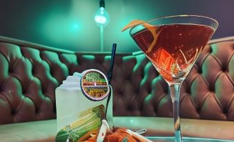 a table with a bowl of appetizers and a glass of red cocktail next to it at The Peppermill Town House Hotel & Restaurant