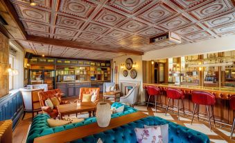 a room with a couch , chairs , and tables is decorated with red and blue upholstery at Grosvenor Pulford Hotel & Spa