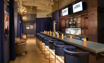 "a modern bar with blue chairs , wooden shelves , and two large screens displaying the words "" bar 2 4 ""." at Hilton Lexington/Downtown