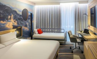 a hotel room with two beds , one on the left and one on the right side of the room at Novotel Leeds Centre