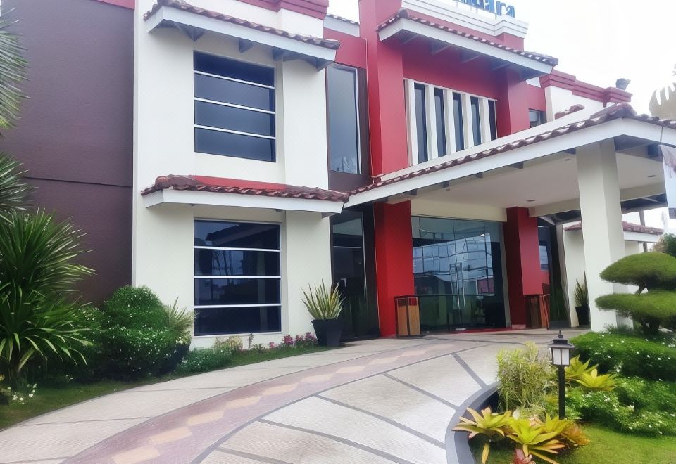 "a large building with a red and white color scheme , featuring a sign that reads "" sam" at Hotel Bandara Syariah