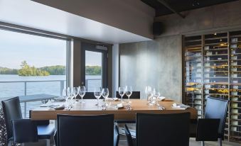 a dining room with a long wooden table set for a meal , surrounded by chairs at Estérel Resort
