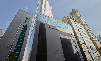 a tall building with a black and white color scheme is surrounded by other skyscrapers at Shilla Stay Dongtan