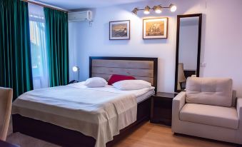 a clean and well - organized bedroom with a comfortable bed , a couch , and a tv . the room is clean and well - organized at Hotel THR Center