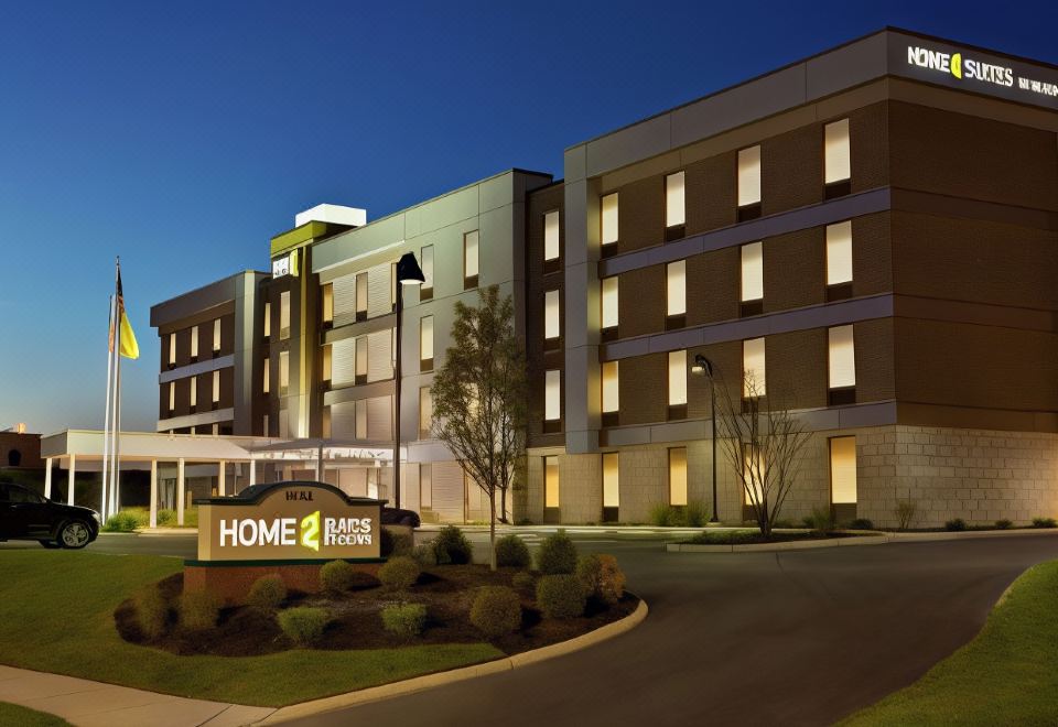 "a large , modern hotel building with a sign that reads "" home 2 suites by hilton "" in front of it" at Home2 Suites by Hilton Lawrenceville Atlanta Sugarloaf