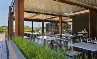 an outdoor dining area with a wooden roof and greenery , providing shade and a pleasant atmosphere at Quarters at Flinders Hotel