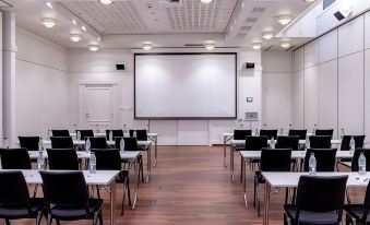 a large conference room with chairs arranged in rows and a projector screen mounted on the wall at Clarion Hotel Bergen