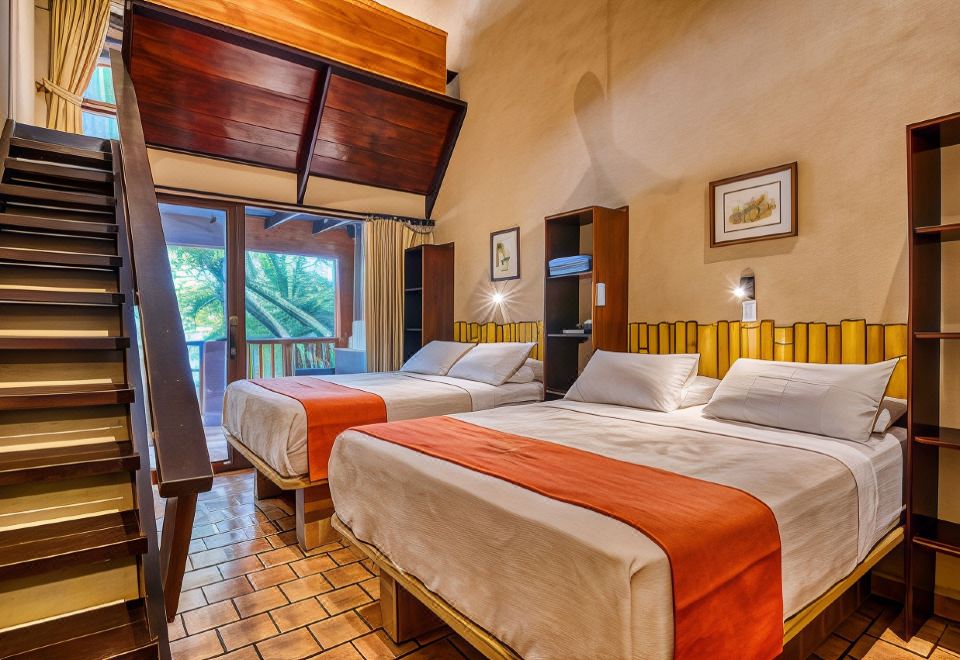 a hotel room with two beds , one on the left and one on the right side of the room at Ylang Ylang Beach Resort