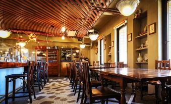 a dining room with a wooden table and chairs , a wine cabinet , and a ceiling covered in bamboo at Fukui Hotel