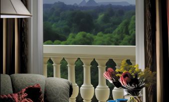 a living room with a couch , a chair , and a table near a window overlooking a beautiful landscape at Four Seasons Hotel Cairo at the First Residence