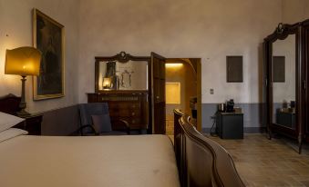a modern living room with wooden furniture , including a bed and chair , as well as a couch and television at Castello di Semivicoli