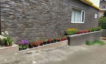 a stone wall with a window and flowers in the window boxes next to it at Sleeping Buddha